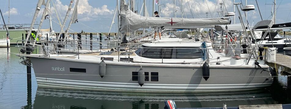 Seitenansicht der Segelyacht Sirius 35DS „Sunball“ mit grauem Rumpf am Liegeplatz in Heiligenhafen – Yachtcharter Ostsee